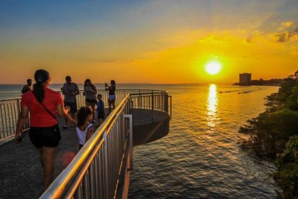 Pessoas apreciando o pôr do sol em Manaus, com um dia quente de 35°C.