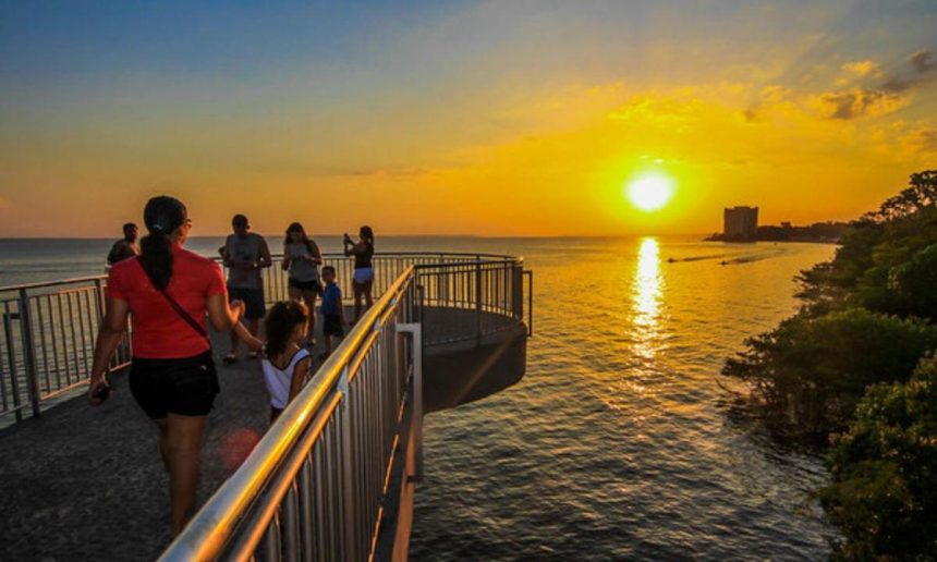 Pessoas apreciando o pôr do sol em Manaus, com um dia quente de 35°C.