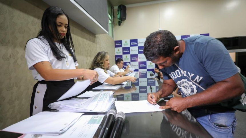 Pessoas assinando documentos em evento da CNH Social no Amazonas.