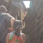 Pessoas reunidas em um local nº Nova Aleixo onde houve um homicídio com estrutura precária, possivelmente favela.