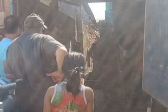 Pessoas reunidas em um local nº Nova Aleixo onde houve um homicídio com estrutura precária, possivelmente favela.