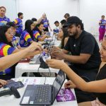 Pessoas trocando pulseiras de acesso em evento #SouManaus Passo a Paço 2025.