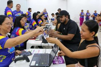Pessoas trocando pulseiras de acesso em evento #SouManaus Passo a Paço 2025.