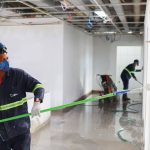 Pintor utilizando rolo em obra de construção civil