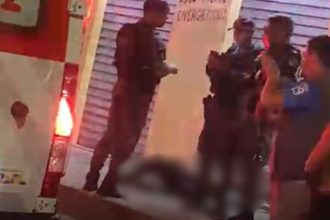 Polícia e corpo no local de crime após assalto a mercadinho no Brasil.