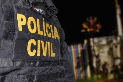 Policial civil com colete tático, cena de investigação noturna.