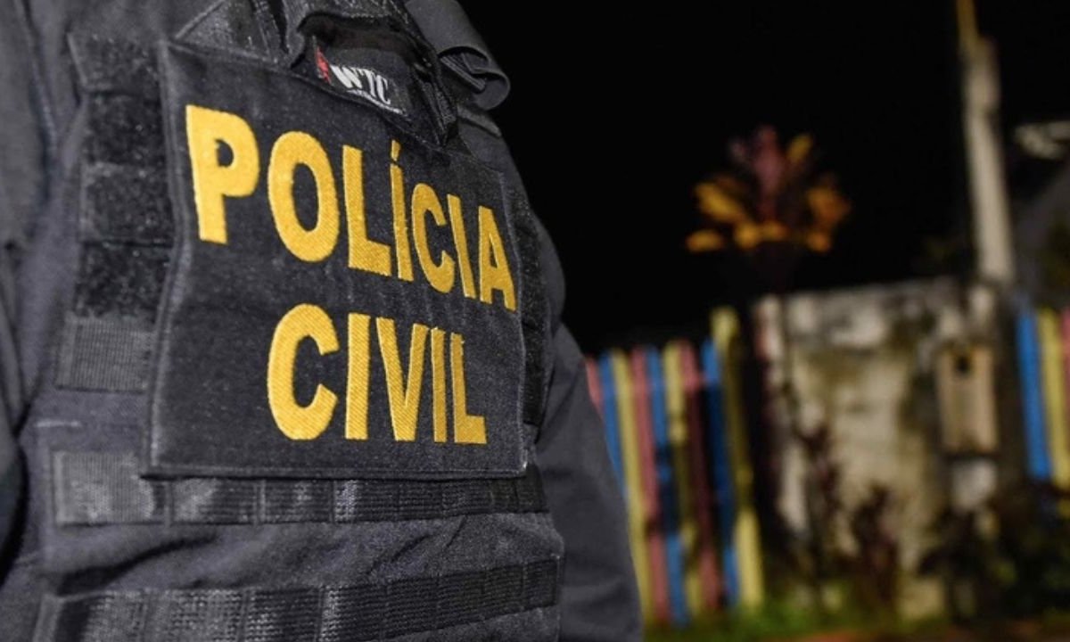Policial civil com colete tático, cena de investigação noturna.