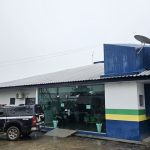 Prédio da Polícia Civil com viatura estacionada e motocicleta.