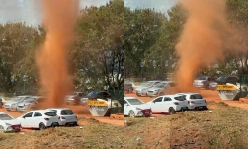 Redemoinho de poeira em Brasília com carros ao fundo.