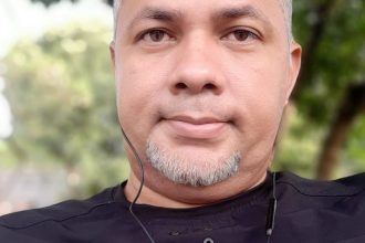 Retrato de homem com barba e camisa preta.