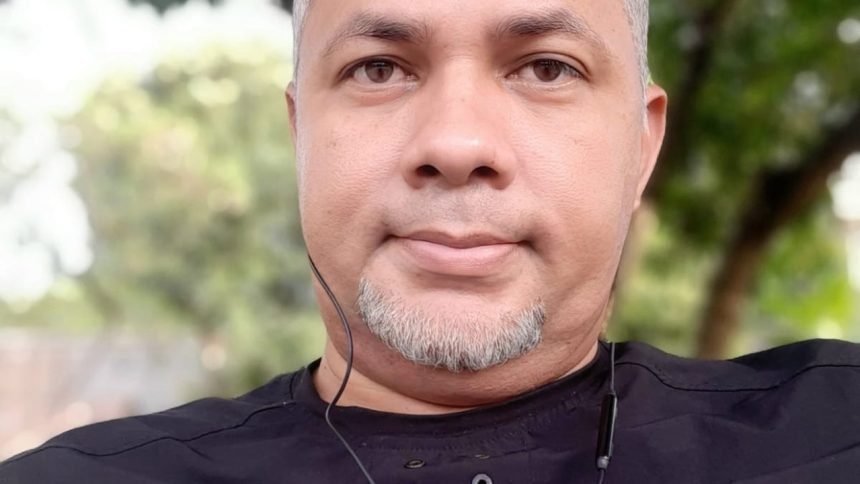 Retrato de homem com barba e camisa preta.