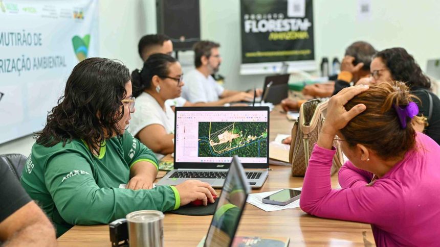 Reunião de trabalho com pessoas analisando dados em laptops, provavelmente sobre questões ambientais.
