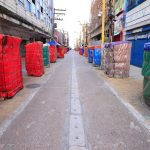 Rua histórica do centro de Manaus com barracas cobertas por lonas coloridas.