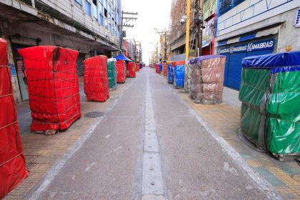 Rua histórica do centro de Manaus com barracas cobertas por lonas coloridas.