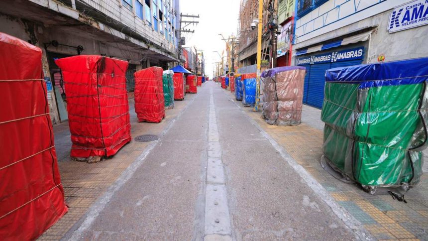 Rua histórica do centro de Manaus com barracas cobertas por lonas coloridas.
