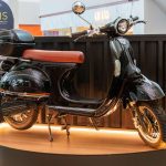 Scooter elétrica preta exposta em shopping, destaque para sorteio de Dia dos Pais.
