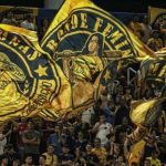 Torcedores do Amazonas FC com bandeiras personalizadas no estádio.