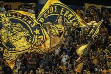 Torcedores do Amazonas FC com bandeiras personalizadas no estádio.