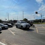 Trânsito na Avenida Silves com carros e motos, sob céu azul e sinalização.