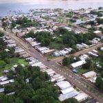Vista aérea de cidade Fonte Boa com casas, vegetação densa e rio ao fundo