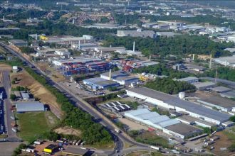 Vista aérea de uma área industrial com contêineres e edifícios.