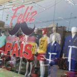 Vitrine de loja com decoração do Dia dos Pais, com manequins vestidos com roupas esportivas.