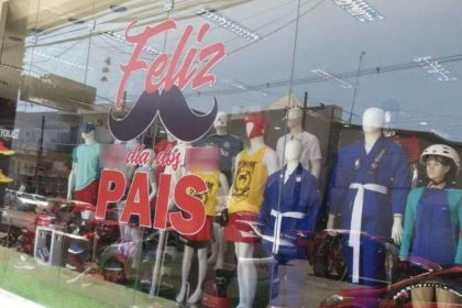 Vitrine de loja com decoração do Dia dos Pais, com manequins vestidos com roupas esportivas.