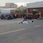 Acidente com vítima fatal envolvendo moto e ônibus. Cena no local com pessoas e veículos.