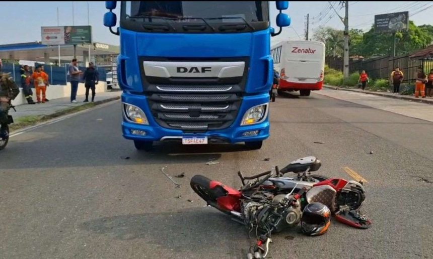 Acidente de trânsito: moto danificada após colisão frontal com carreta azul.