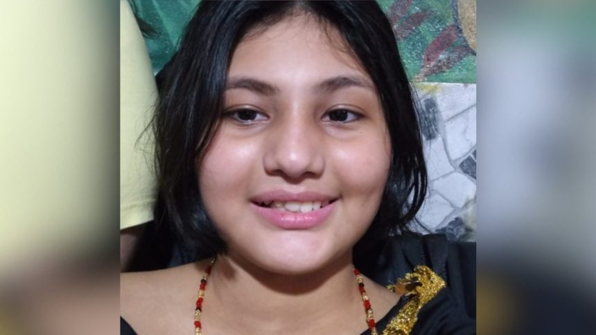 Adolescente sorrindo com cabelo escuro e colar.