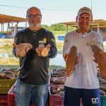 Agricultores do Amazonas exibem mandiocas, produto agrícola regional, promovendo o cooperativismo.