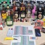 Apreensão de bebidas alcoólicas falsificadas, incluindo garrafas de uísque, em uma operação policial.