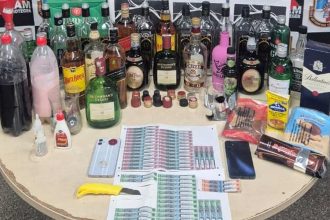 Apreensão de bebidas alcoólicas falsificadas, incluindo garrafas de uísque, em uma operação policial.