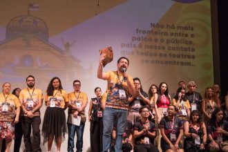 Apresentação em evento do Festival de Teatro da Amazônia, com pessoas no palco e mensagem.