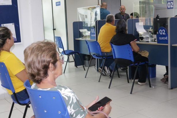 Atendimento em guichês da Manausprev com pessoas aguardando e funcionários em atendimento.