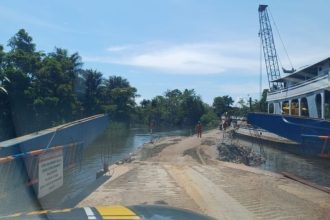 Balsa de transporte fluvial em rio, com obras finalizadas da nova ponte BR-319 no Amazonas.