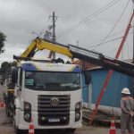Caminhão com guindaste trabalha em poste de energia elétrica em Manaus.