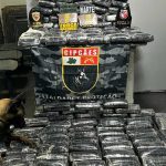 Cão farejador em apreensão de drogas com policiais em Coari, Amazonas. Carga apreendida vale R$ 3,6 milhões.