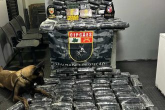 Cão farejador em apreensão de drogas com policiais em Coari, Amazonas. Carga apreendida vale R$ 3,6 milhões.
