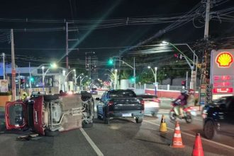 Carro capotado em via pública, causando congestionamento. Acidente na Rua Salvador, Manaus.