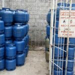 Depósito de botijões de gás azul com sinalização de perigo e proibição de fumar.