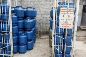 Depósito de botijões de gás azul com sinalização de perigo e proibição de fumar.