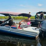 Dois barcos em um rio, com pessoas a bordo, possivelmente em atividade policial ou de fiscalização.