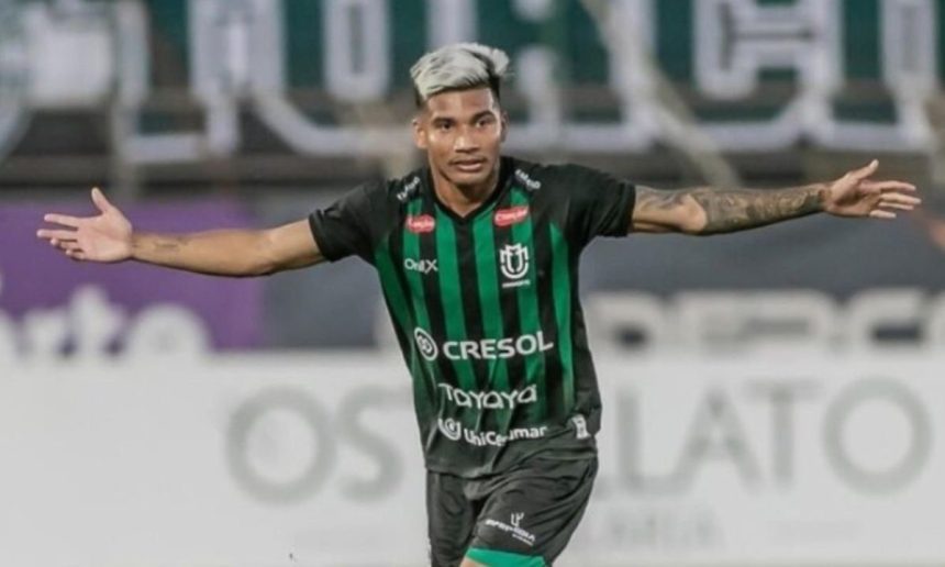 Edison Negueba, jogador de futebol do Juventude, celebra com os braços abertos.