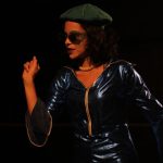 Ensaio da peça "Oceanos" com atriz usando roupa azul e óculos escuros