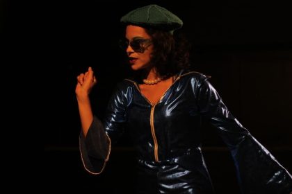 Ensaio da peça "Oceanos" com atriz usando roupa azul e óculos escuros