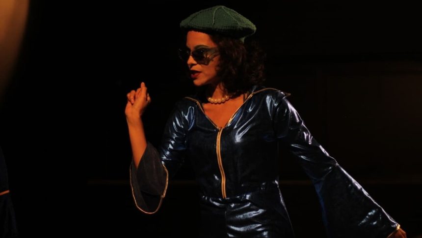 Ensaio da peça "Oceanos" com atriz usando roupa azul e óculos escuros