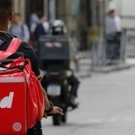 Entregador iFood em moto com mochila vermelha, representando oportunidades de emprego no Amazonas.