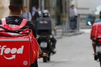 Entregador iFood em moto com mochila vermelha, representando oportunidades de emprego no Amazonas.