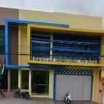 Fachada da Câmara Municipal de Coari, prédio com arquitetura moderna e bandeiras hasteadas.